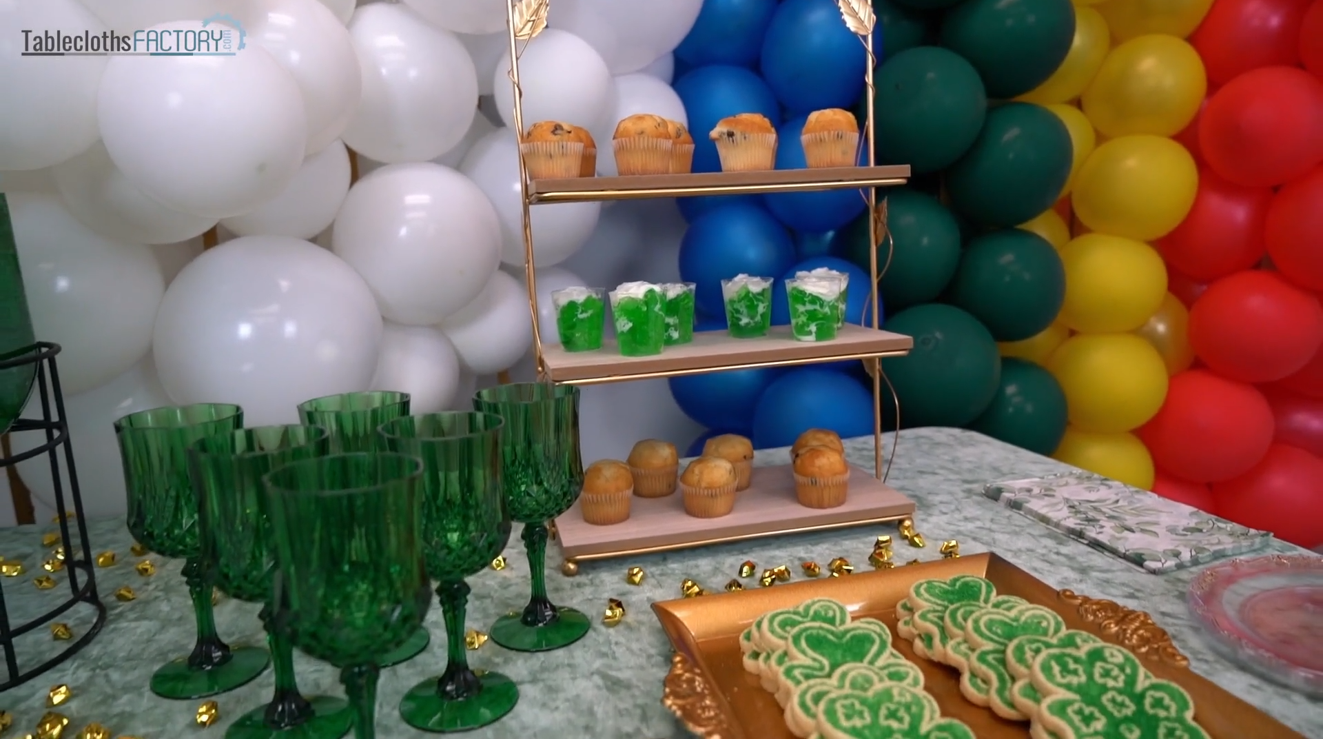Cupcake stand, green wine glasses, and gold tray on the table