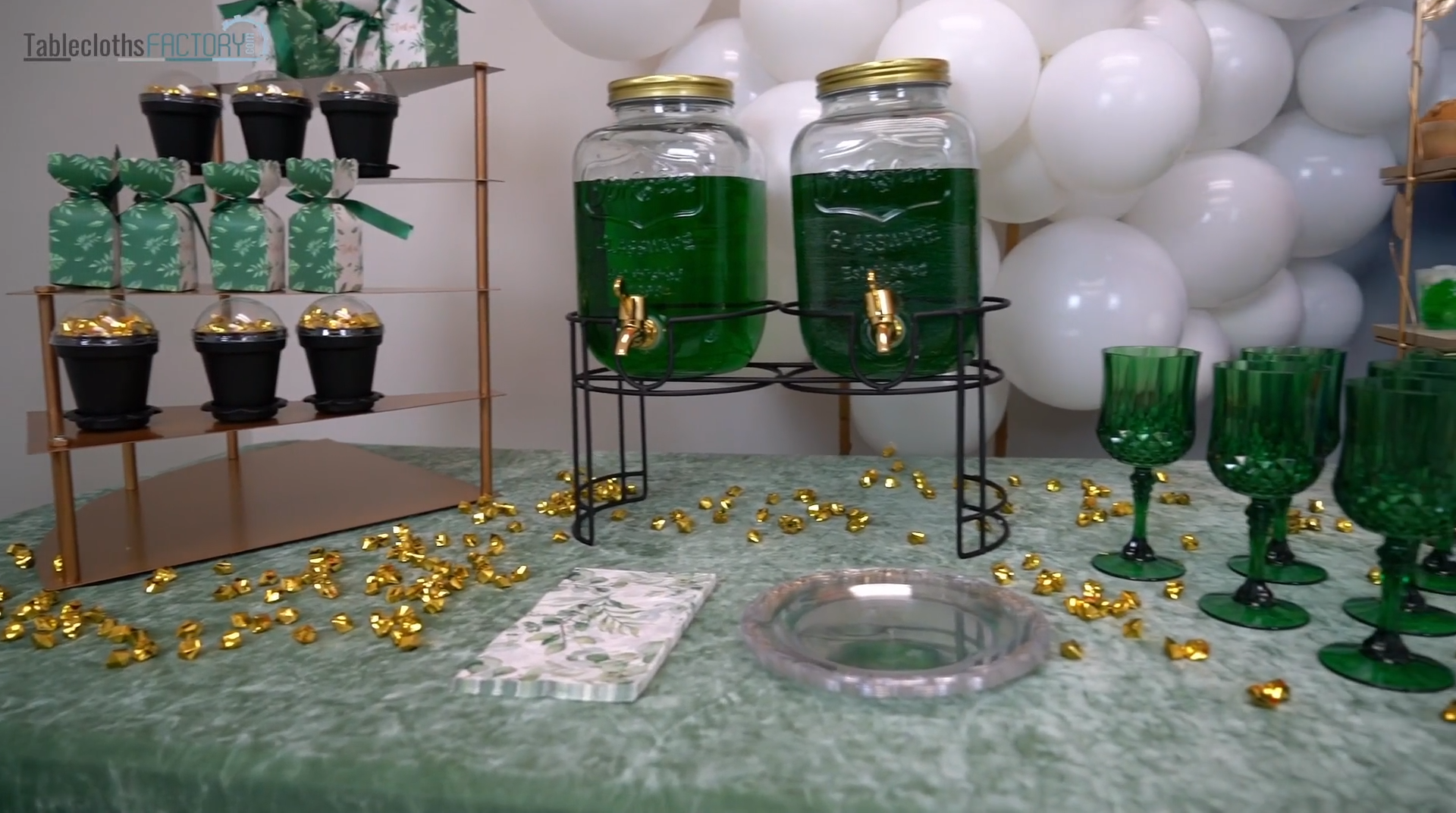 Beverage dispenser stands, leaf print paper napkins, and clear plates on the table