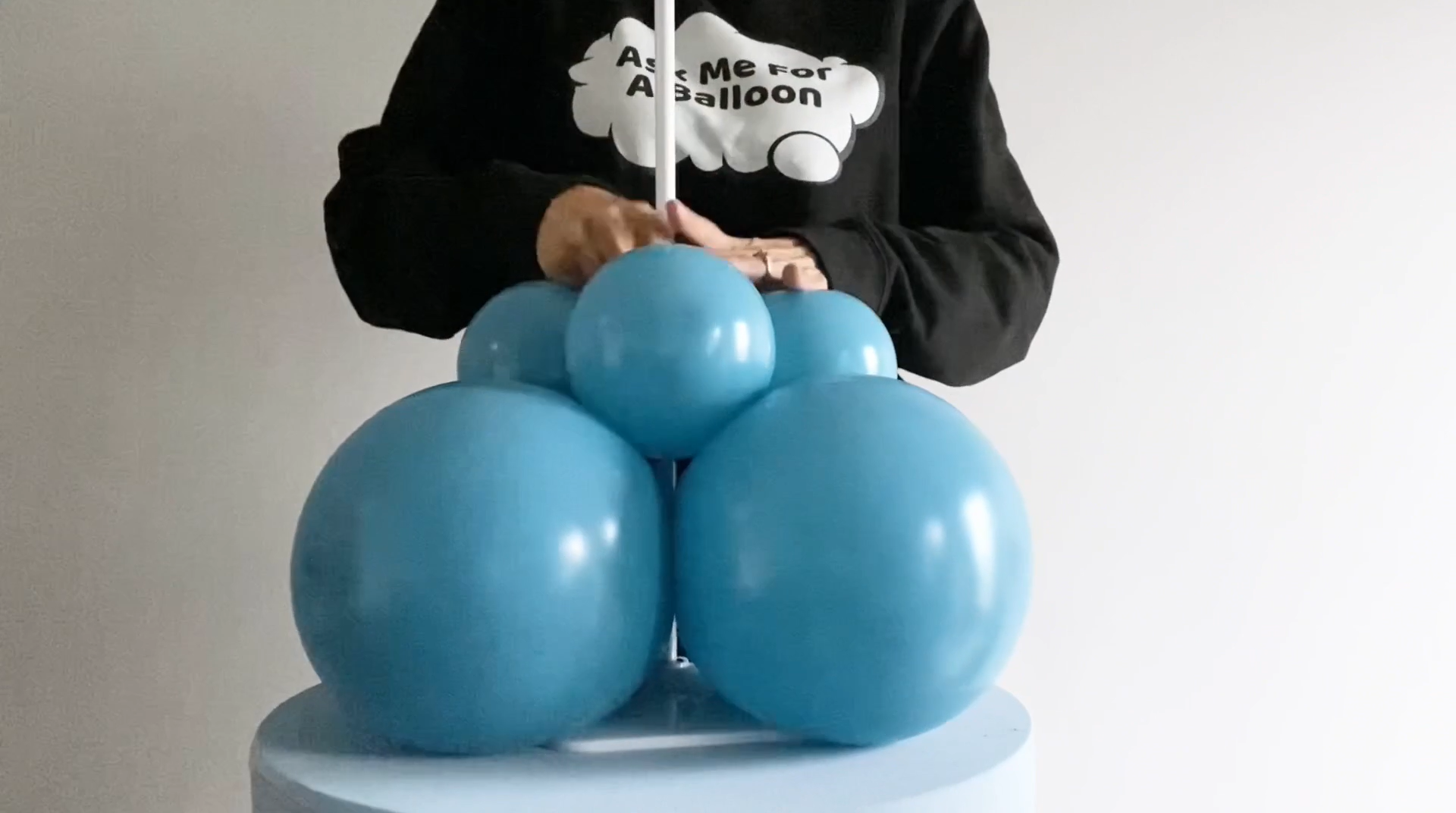 Layer of blue balloons on a column stand