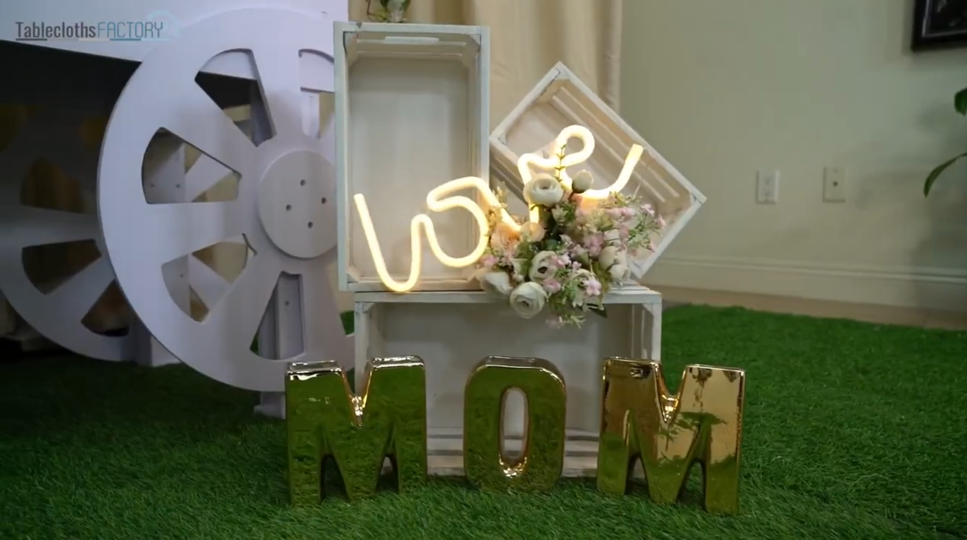 Elegant Mother's Day decor with 'LOVE' neon sign and floral arrangements.