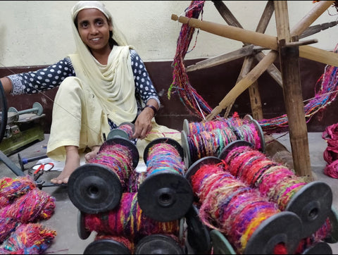 Woman spinning recycled sari yarn