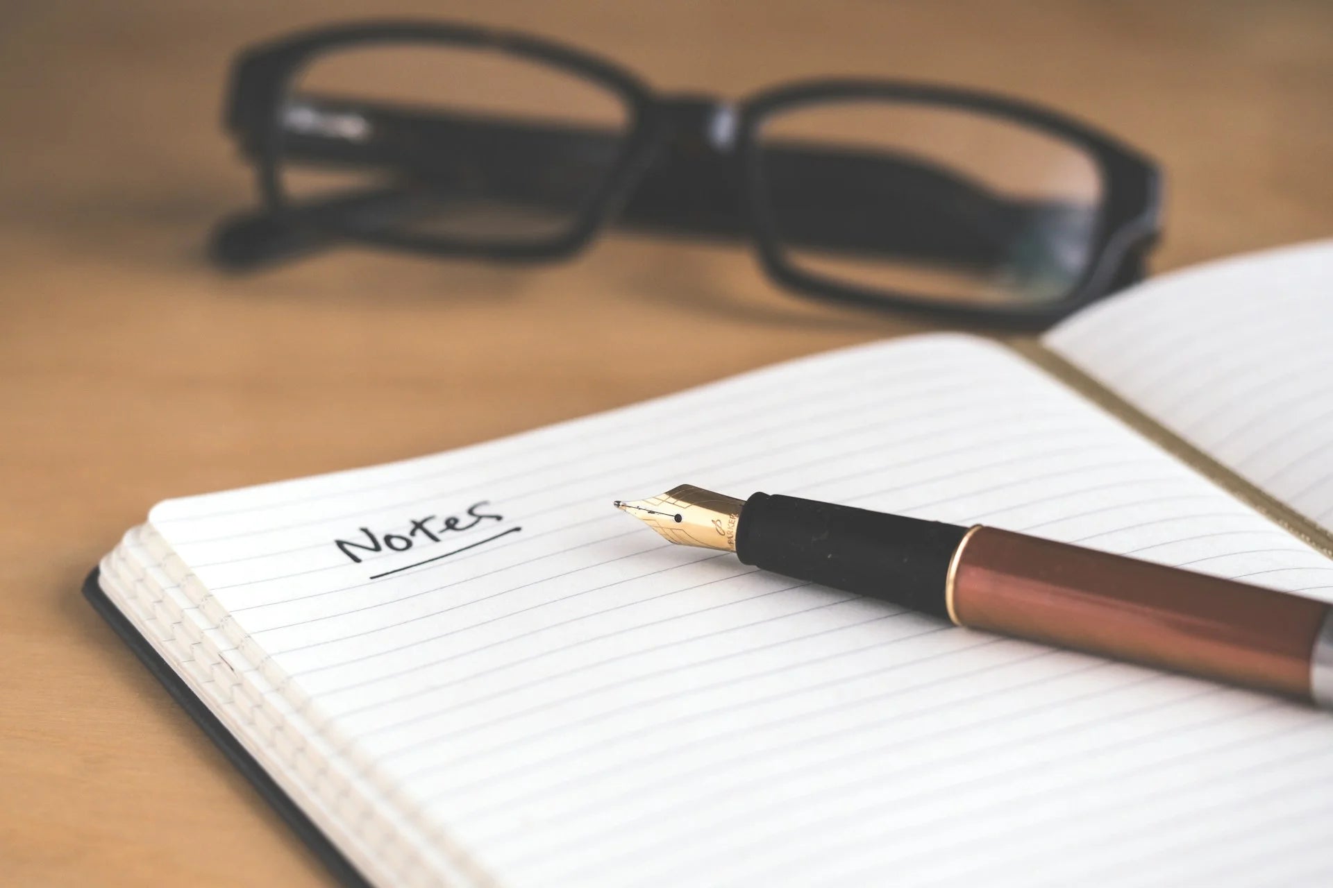 notes-pen-on-book-with-glasses