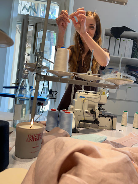 Giulia smiling at work in the atelier, in the background the workbench