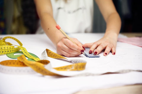 ide the Marta Scarampi atelier, the seamstress takes measurements to cut the fabric.