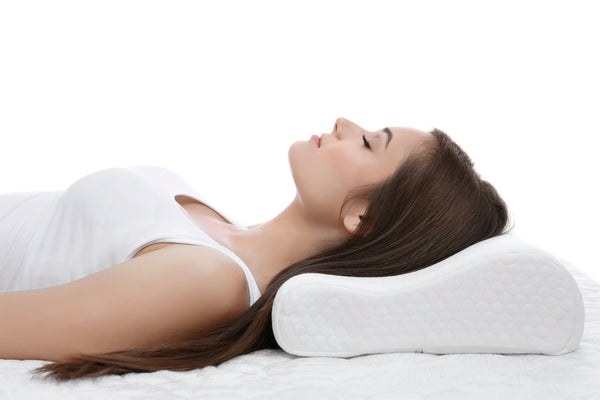 Woman laying on an ergonomic lash pillow. Cartel Lash