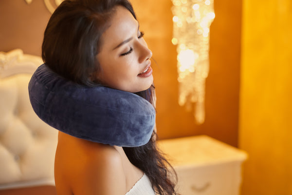 Woman with eyelash extensions using a neck lash pillow. Cartel Lash