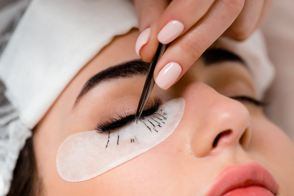Lash mapping during an eyelash extension treatment at eyelash salon. Cartel Lash