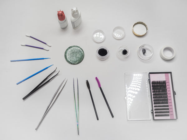 Eyelash extension kit and tools are laid out on the table. Cartel Lash