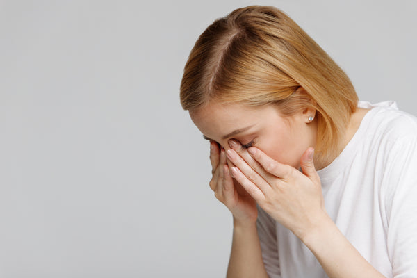 Woman rubbing eyelash extensions from allergies. Cartel Lash