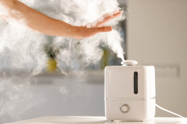 Hand touching humidifier in a lash room to help with lash retention. Cartel Lash 