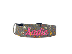 A gray dog collar with little ghosts and candy corns.