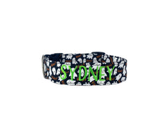 A black dog collar with white ghosts on it.
