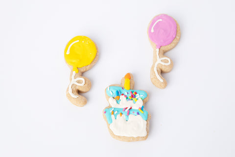 Two dog-friendly balloon cookies and one cake-shaped cookie.