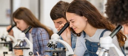 Teenagers using microscopes