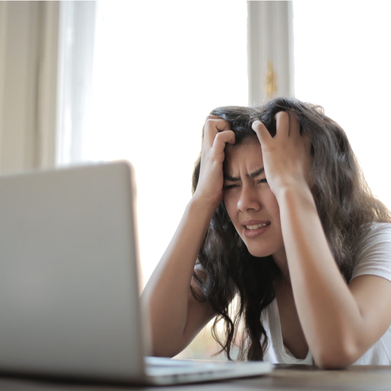 woman looking frustrated at laptop screen