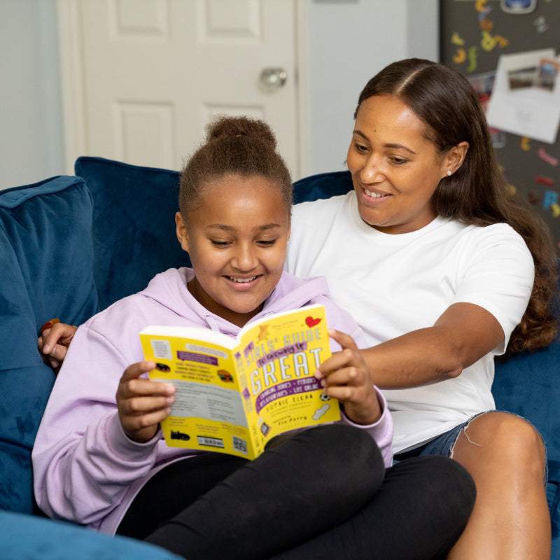daughter reading book with mother