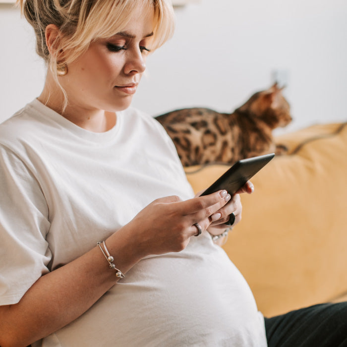 pregnant woman reading from tablet
