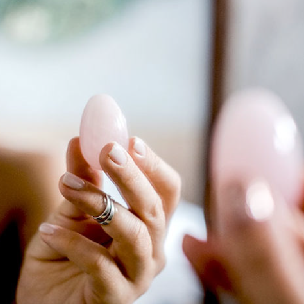 woman's hand holding pink yoni egg