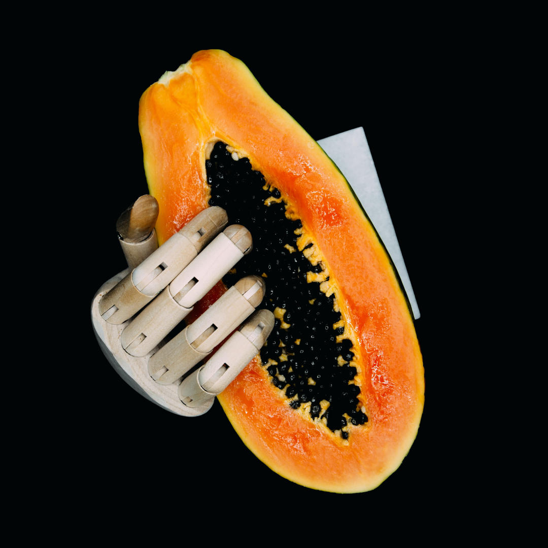 wooden hand holding a papaya fruit