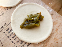 hatch green chile piled on empanada dough - making empanadas