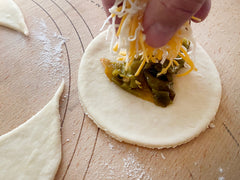 Piling four cheese mix on hatch green chile for empanada recipe