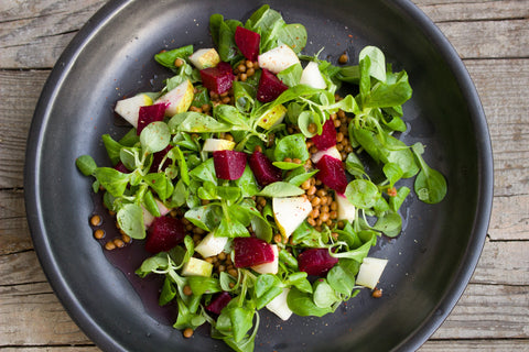 Black plate with salad on it