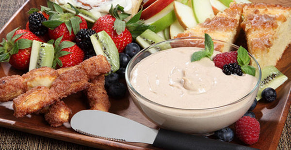 A delightful bowl of RADA Cinnamon Roll Sweet Dip next to sliced strawberries and kiwis