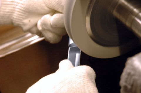 A protected hand putting the final sharpening edge on a Rada Regular Paring Knife