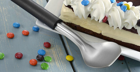 rada-stainless-steel-ice-cream-scoop-with-black-resin-handle-R137-next-to-dessert-cake