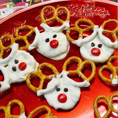 Some red nosed reindeer treats with pretzel antlers laid out on red platter
