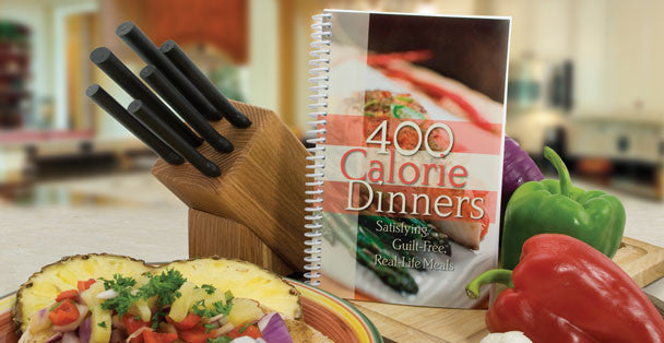 400 Calorie Dinners cookbook next to a Rada wooden knife block and fresh vegetables