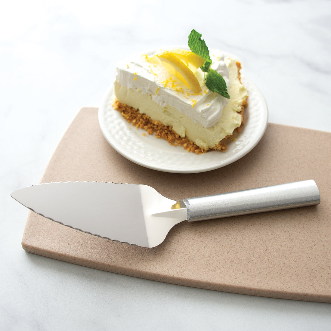 Rada Cutlery Serrated Pie Server with silver handle and slice of lemon pie. 
