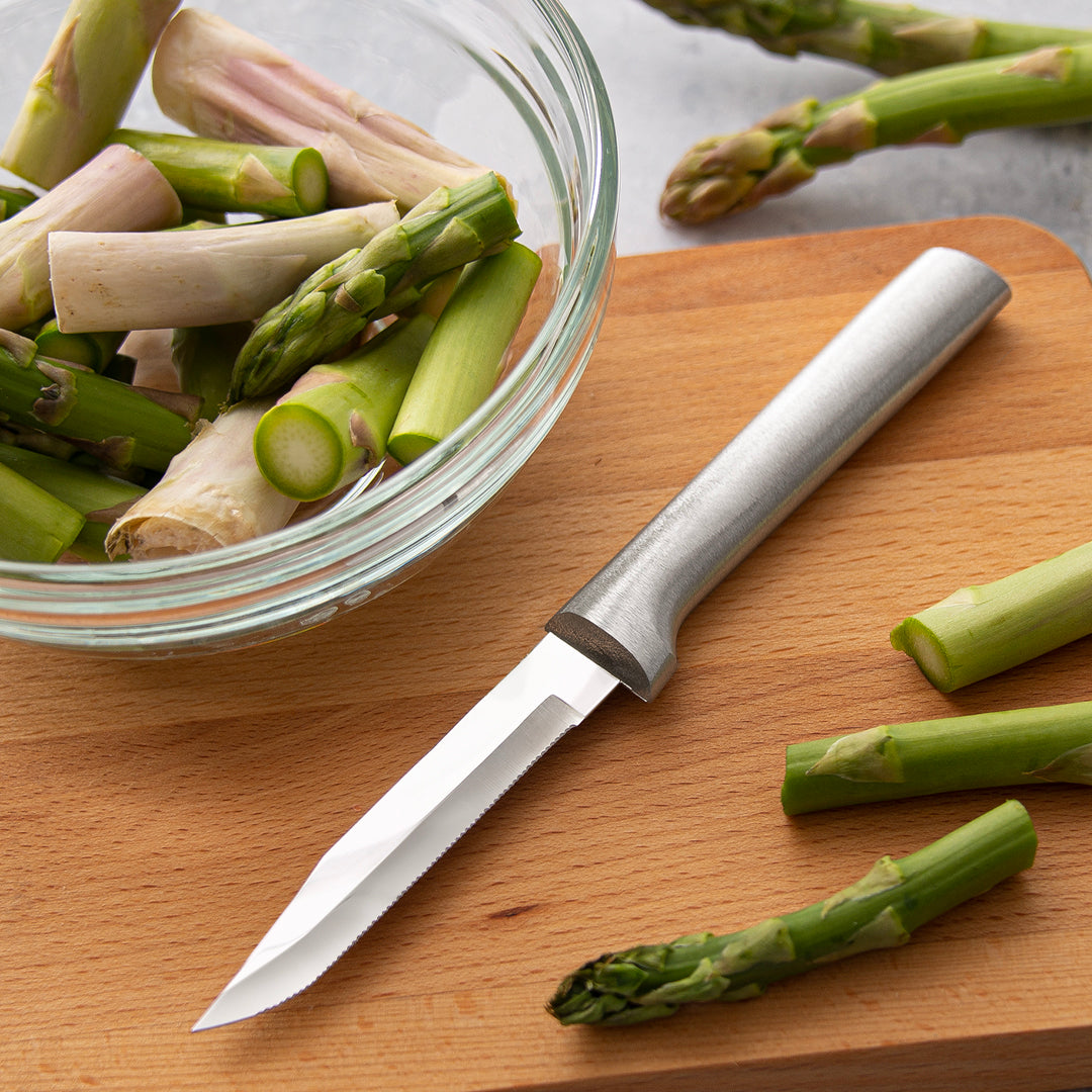 Rada Cutlery Serrated Regular Paring on cutting board with bowl of asparagus.