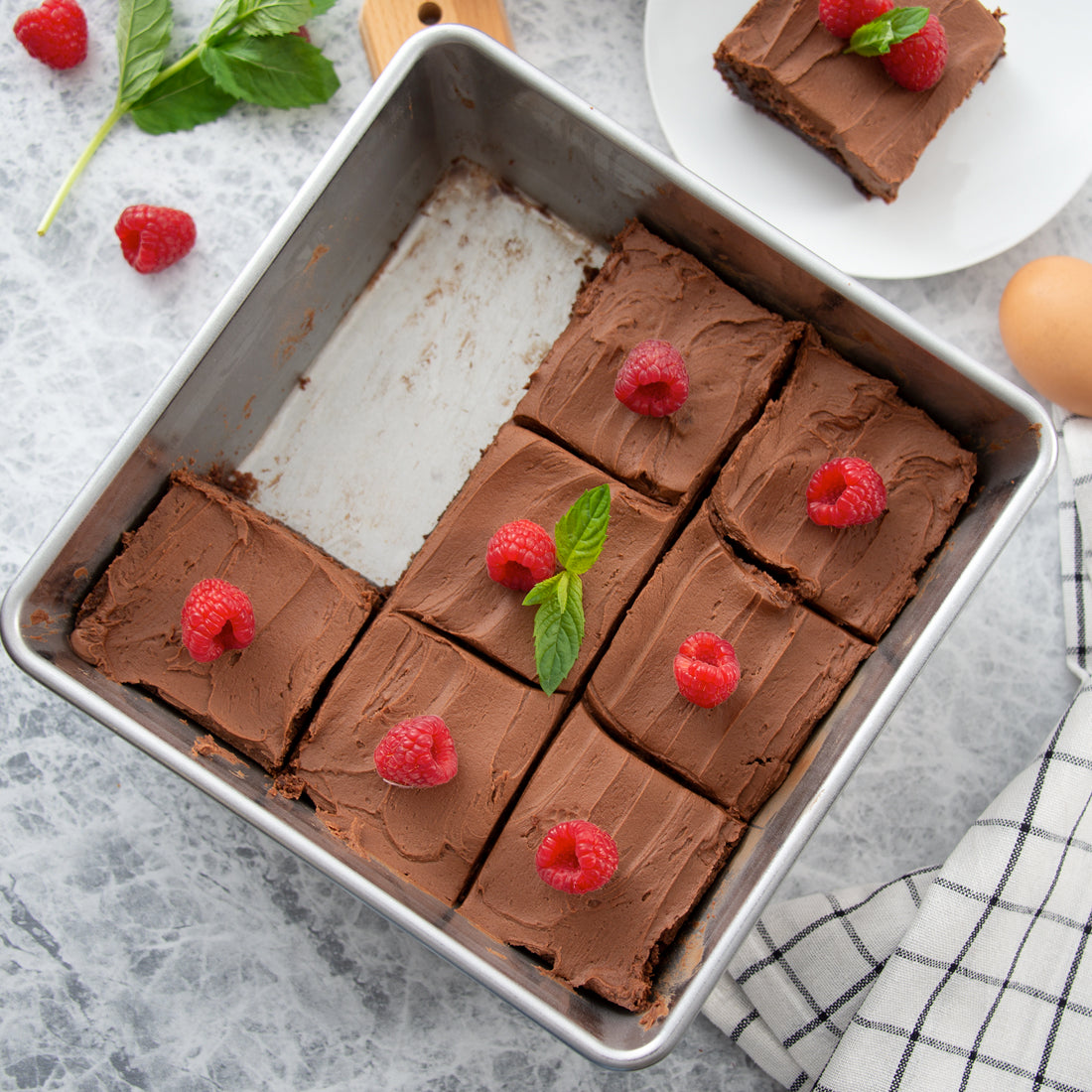 Rada Cutlery Square Pan with brownies and raspberry garnishes.