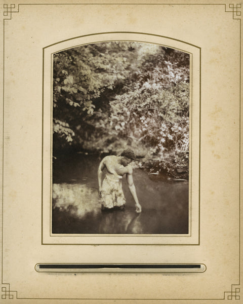 A print of a man standing in a river, reaching towards the water.