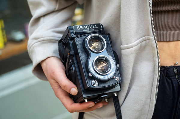 A Seagull 4A TLR Camera being held by a woman.