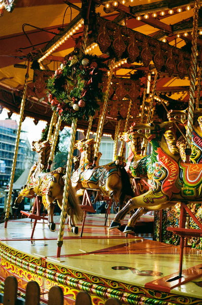 A carousel, with two horses in the front of the frame.