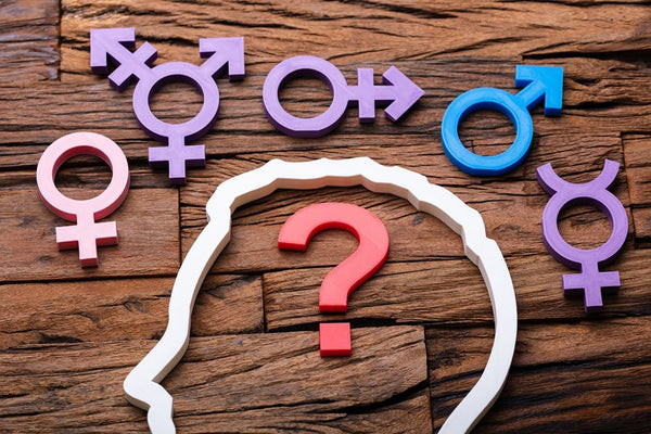 An illustration of a human brain surrounded by question marks and gender symbols, representing the concept of gender awareness and exploration