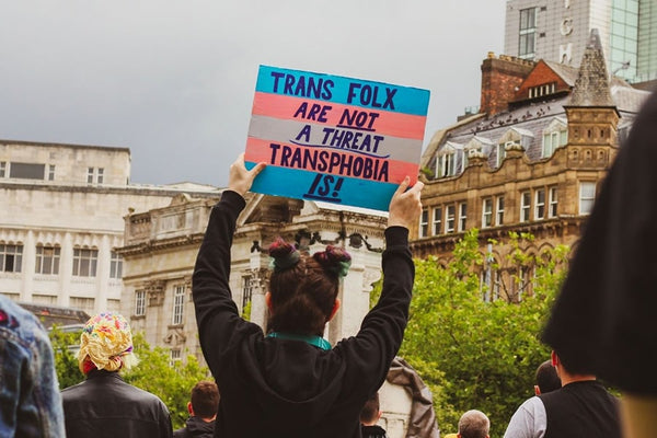 A person holding a protest sign advocating for transgender rights.