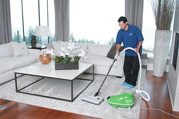 AspenClean professional cleaner is vacuuming the floor  