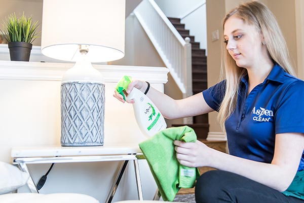 AspenClean professional cleaner is using AspenClean natural all purpose cleaner to clean the table