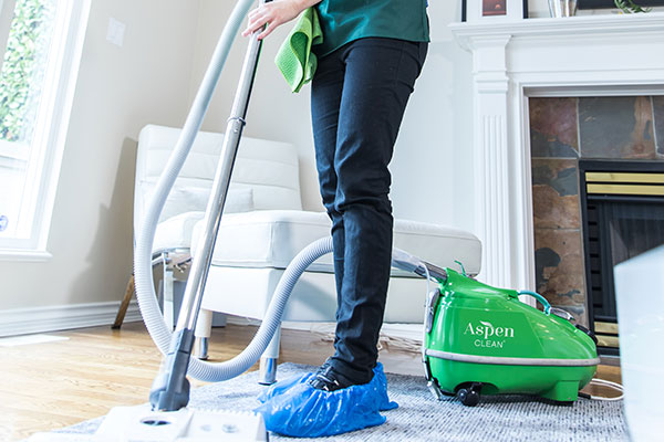 the AspenClean professional cleaner is using a vacuum with a high-efficiency air particulate to clean the house