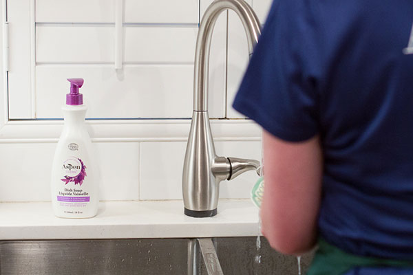 a man is doing the dishes using AspenClean Natural Dish Soap Lavender and Lemongrass