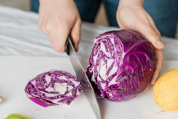 Someone is cutting the red cabbage