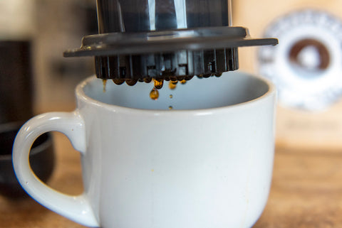 Lifting dripping AeroPress off coffee mug