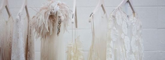 Multiple vintage wedding gowns hanging up. Photo Credit: Charisse Kenion via Unsplash