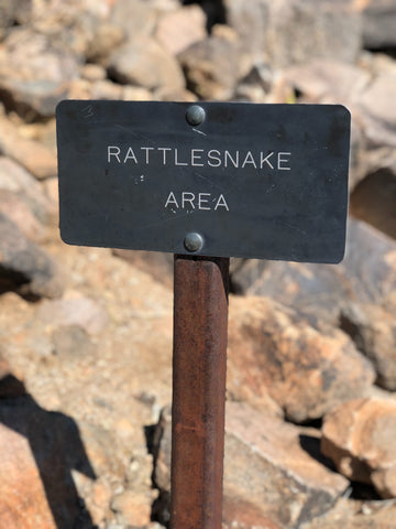 sign on rocky trails warning of rattlesnakes 