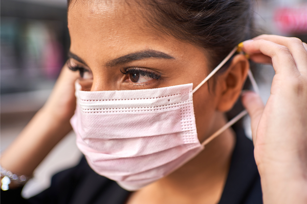 woman putting on face mask