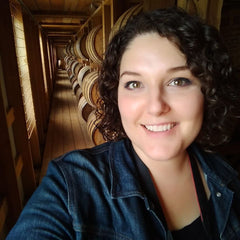 Maggie Kimberl in front of bourbon barrels