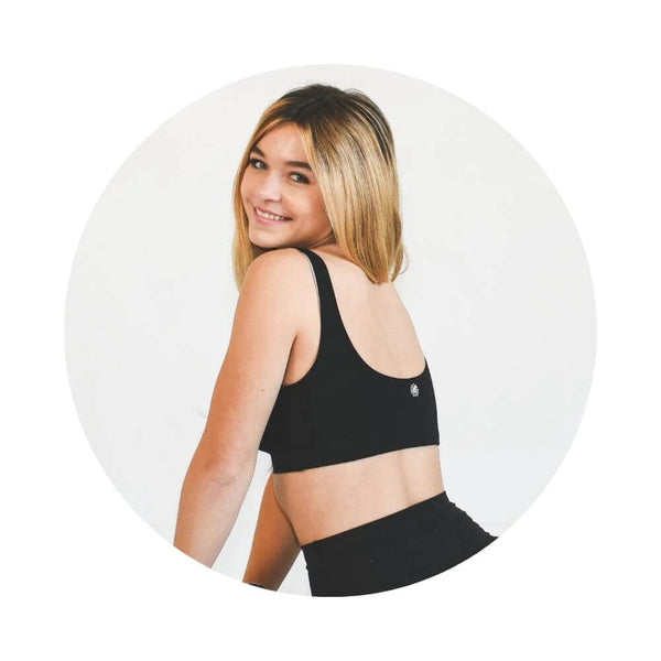 Teen girl wearing a Bleuet Aster Organic Bra in black.